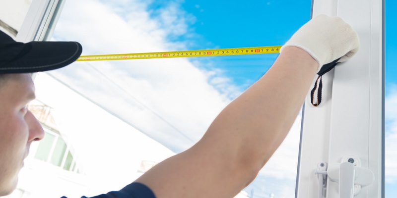 Ouvrier prenant les mesures d'une vitre