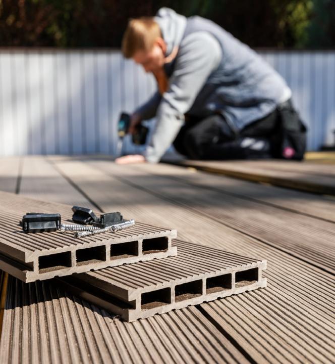 Pose d'une terrasse en composite Opérateur posant des lames de terrasse en composite